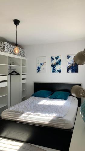 - une chambre avec un lit et des photos sur le mur dans l'établissement Villa climatisée dans Domaine privé Aix en Provence, à Aix-en-Provence