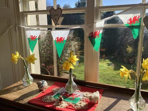 a window with three vases on a table with flowers at Bryn Guest House in Conwy