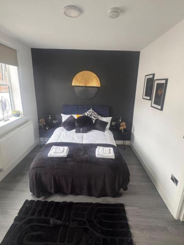 a bedroom with a large bed with a black wall at Liverpool RD Warrington in Great Sankey