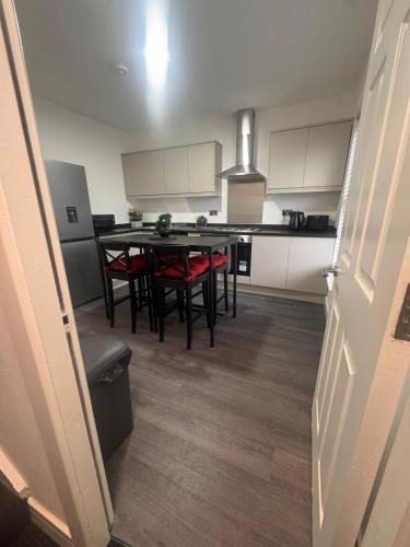 a kitchen with a table and some chairs in it at Liverpool RD Warrington in Great Sankey