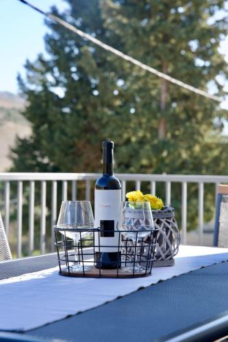 a bottle of wine and two glasses on a table at Apartman Nives in Kremena