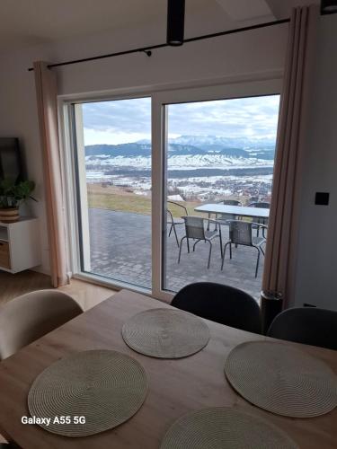 a dining room with a table and a large window at Domek Na Sapisku in Szlembark
