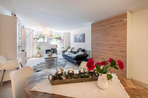 un soggiorno con tavolo con fiori rossi di MarEwa Ferien a Mechernich