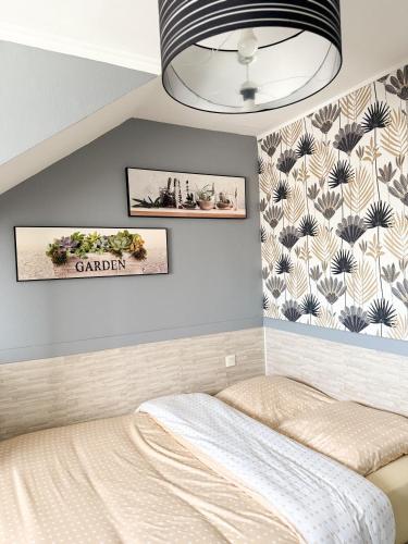 une chambre avec un lit et deux tableaux au mur dans l'établissement Les clés angevines Chambre numéro 7, à Angers