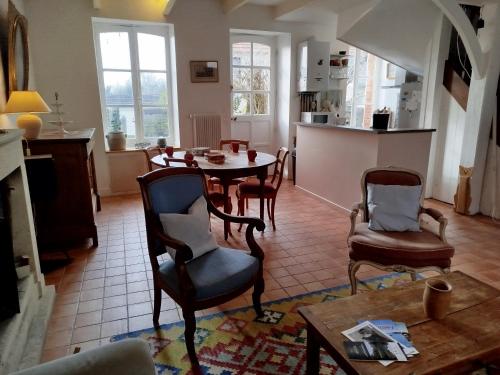 une cuisine et un salon avec une table et des chaises dans l'établissement Gite Les Hirondelles en Baie du Mont St Michel, à Saint-Jean-le-Thomas