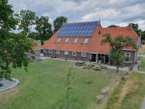 una casa con tetto e pannelli solari di Anna's Bêd & Brochje en vakantieverblijf a Donkerbroek