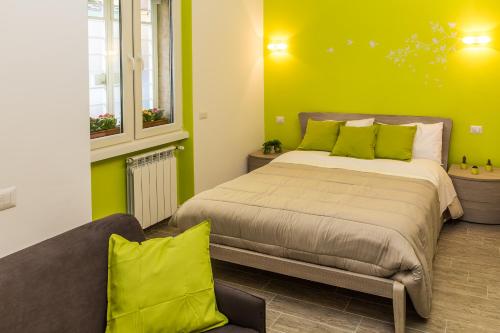 ein Schlafzimmer mit einem Bett mit grünen Wänden und einem Sofa in der Unterkunft The Green Corner in Rom