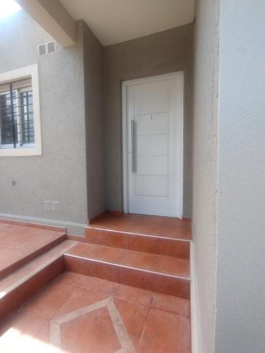 a room with a white door and a tile floor at Lihuel 1 AG in Alta Gracia