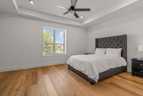a white bedroom with a bed and a ceiling fan at Muncie U Too at Trinity Grove in Dallas