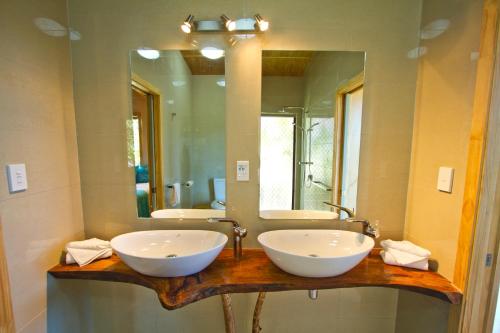 ein Badezimmer mit zwei Waschbecken und einem großen Spiegel in der Unterkunft Paradise Holiday Homes Rarotonga in Rarotonga
