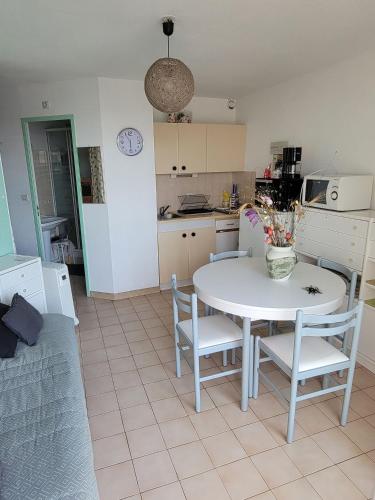 une cuisine et une salle à manger avec une table et des chaises dans l'établissement Studio centre port Valras, à Valras-Plage