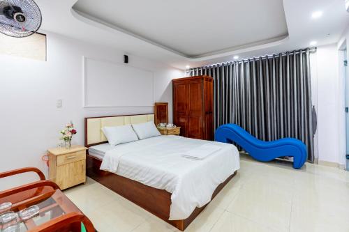 Un dormitorio con una cama y una silla azul. en Nhà Nghỉ Light Hotel, en Hanói