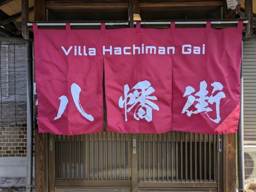 a red banner on a gate with a villa hakimian cell at Villa Hachiman-gai ヴィラ八幡街 in Omihachiman