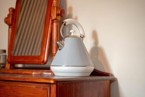 a tea kettle sitting on top of a wooden dresser at Prime location rooms in high street in Fort William