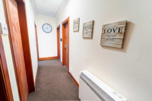 a hallway with a room with a clock on the wall at Prime location rooms in high street in Fort William