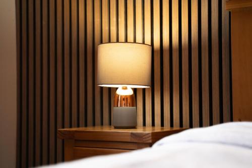 a lamp sitting on a table next to a bed at Prime location rooms in high street in Fort William