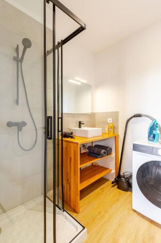 une salle de bain avec douche et lavabo et une machine à laver dans l'établissement Le Briand - Centre Ville - Calme - Terrasse, à Saint-Nazaire