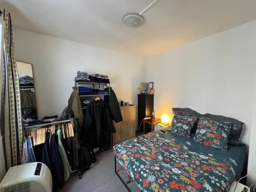 - une chambre avec un lit et une commode avec un ventilateur dans l'établissement Charmant 2P Paris - Haut Parc Belleville, à Paris