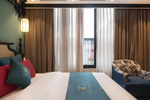 a hotel room with a bed and a chair at Hanoi Bliss Hotel in Hanoi
