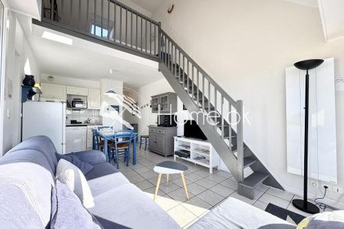 - un salon avec un canapé bleu et un escalier dans l'établissement Charmant T3 duplex - Bord de mer - Terrasse, à Quiberon