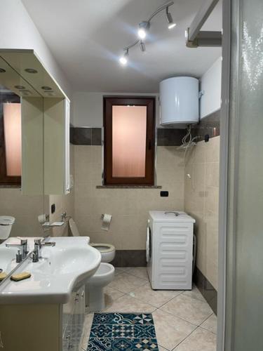 a bathroom with a sink and a toilet at Comfort Apartment in Assemini