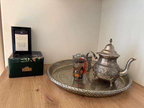 a tray with a tea pot on a table next to a box at Cozy StudioApartment with Graden in Graz Free Parking in Graz