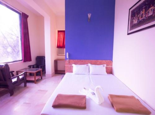 a bedroom with a large bed with a blue wall at Hotel Suriya International in Chennai