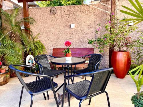 a patio with four chairs and a table with flowers at Lindo quarto Próximo ao centro in Rosário do Sul