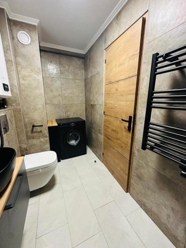 une salle de bain avec toilettes et porte en bois dans l'établissement Résidence le nautica, à Fréjus