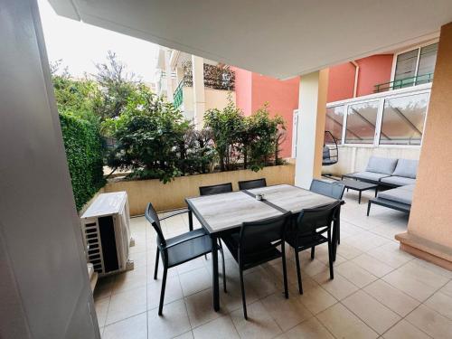 un patio avec une table, des chaises et un canapé dans l'établissement Résidence le nautica, à Fréjus