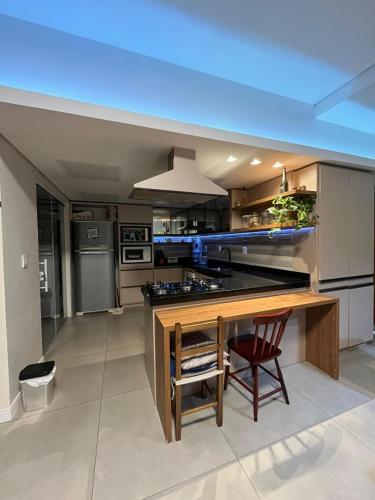 a large kitchen with a wooden table and a counter at Lindo quarto Próximo ao centro in Rosário do Sul