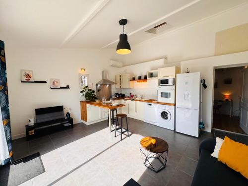 une cuisine et un salon avec un canapé et une table dans l'établissement Appartement Le Cosy de La Ramée, à Tournefeuille