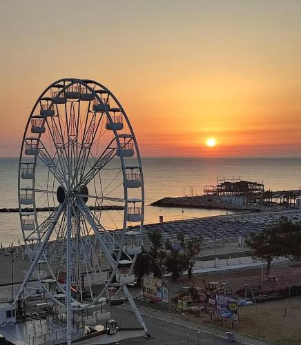 a ferris wheel at a beach with the sunset at Bellavista in San Salvo