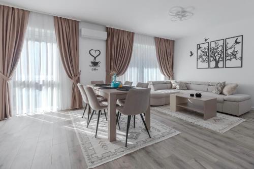 a white living room with a table and chairs at Cream Divine in Oradea