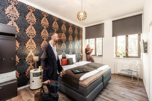 Ein Mann steht in einem Schlafzimmer mit einem Bett in der Unterkunft Zur guten Quelle in Köln