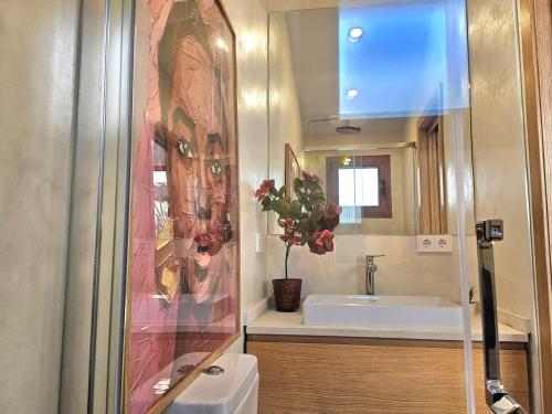 a bathroom with a sink and a toilet and a mirror at ElsPeixets Home Mallorca - ArtHouse in Colonia Sant Jordi