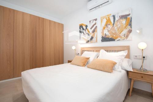a bedroom with a large white bed with two pillows at ElsPeixets Home Mallorca - ArtHouse in Colonia Sant Jordi