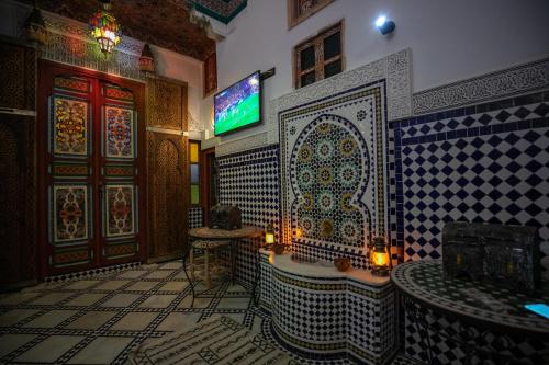 a bathroom with a tub and a tv on a wall at Dar Amazigh in Fès