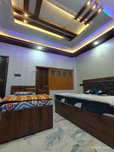 two beds are in a room with a ceiling at Raghunandan Home stay in Ayodhya