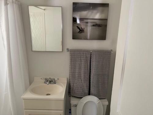 ein Badezimmer mit Waschbecken, Toilette und Spiegel in der Unterkunft Everything you need - 1 BR 1 BA WIFI SMART TV QN Bed Coffee in Wichita