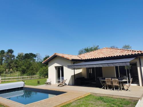 une maison avec une piscine et une terrasse dans l'établissement Villa en lisière de forêt, à Seignosse