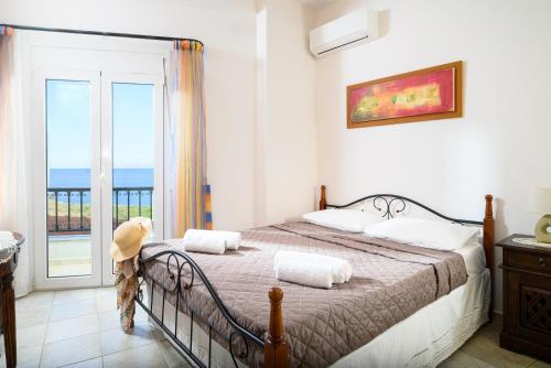 a bedroom with a bed with a view of the ocean at Psaromoura Residence in Agia Pelagia