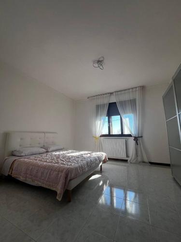 a white bedroom with a bed and a window at Garden Country House in Fogolana