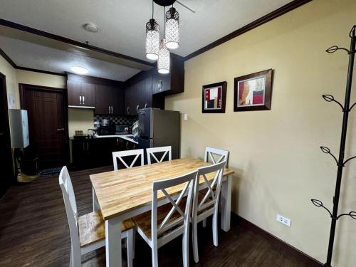 Una cocina y un comedor con mesa y sillas de madera. en Ezwi's Staycation, en Baguio