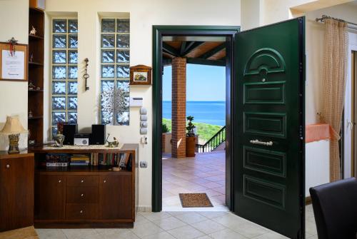 a green door with a view of the ocean at Psaromoura Residence in Agia Pelagia