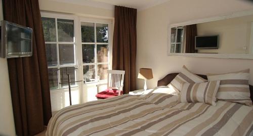 a bedroom with a bed and a large window at Ferienwohnung 1 Rosenberg 32 in Zingst