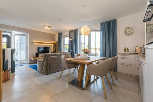 a kitchen and living room with a table and chairs at Victoria Luna Penthouse No 10 Strandstrstr48 in Zingst