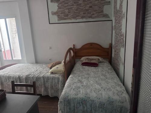 a small bedroom with two beds and a table at Casa Colón en la mancha in Herencia