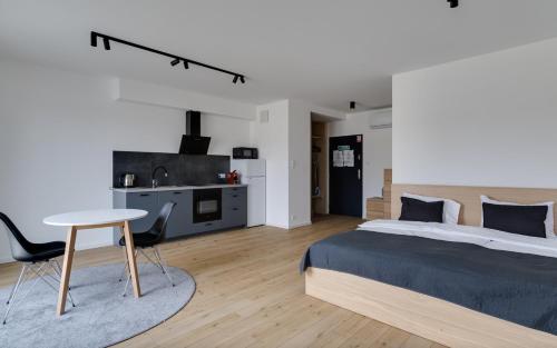 a bedroom with a bed and a table and a kitchen at Poznań Apartments Towarowa in Poznań