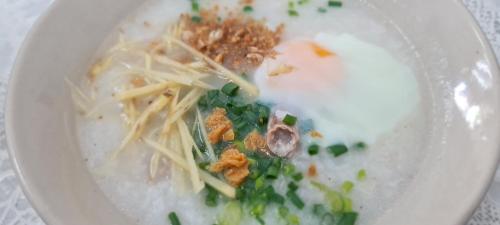 een witte kom gevuld met voedsel op een tafel bij Little Home in Town in Ban Lo Long